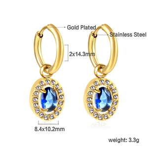 Close-up of gold stainless steel oval hoop earrings with blue stone and white crystals