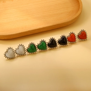 Gros plan de boucles d'oreilles cœur en opale avec bord perlé en plusieurs couleurs