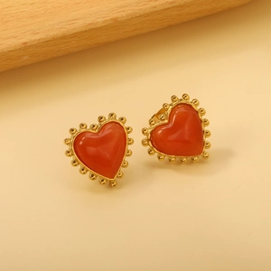 Détail de boucles d'oreilles cœur vintage plaqué or avec opale rouge et perles