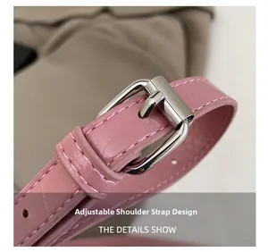 Makroaufnahme des rosa Leder-Schultergurts mit Krokoprägung und verstellbarer Schnalle