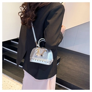 Silver metallic shell bag with gold rivet detailing shown on model for size and style