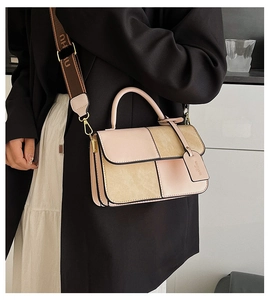 Detail of color-block square bag with textured suede panels and a stylish wide strap