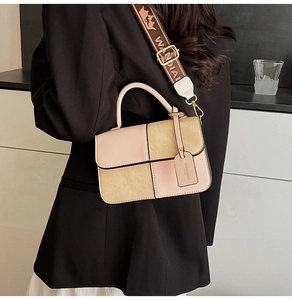 Detail view of pink and tan color-block square bag with wide jacquard shoulder strap