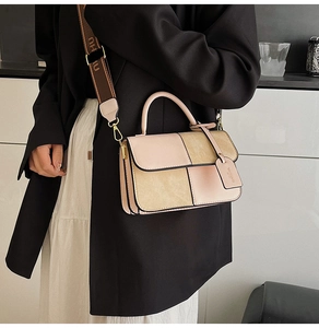 Detail of color-block crossbody bag with wide logo fabric strap and suede texture