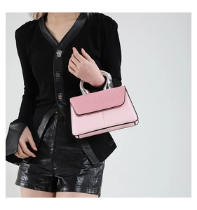 Detail of pink leather handbag with textured flap and elegant silver metal handle