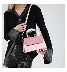 Pink handbag with woven texture lid and irregular silver metal handle worn by a model