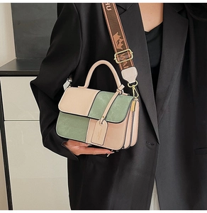 Detail of pink and green patchwork leather crossbody bag with wide printed strap