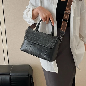 Borsa nera con goffratura a coccodrillo, ampia tracolla intrecciata e manico circolare moderno