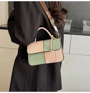 Detail of color-block square bag with pink and green panels and a wide patterned strap