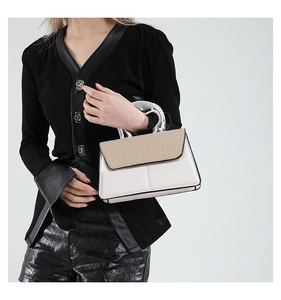 Detail of creative silver metal handle and beige woven texture on a white square bag