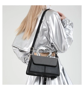Detail view of stylish black small square bag featuring a unique silver metal handle