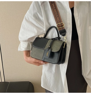 Detail of color-block crossbody bag featuring contrast stitching and jacquard wide strap