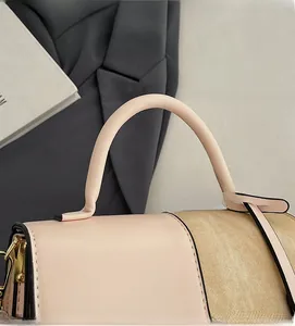 Close-up of pink leather handle and beige textured fabric on a stylish square handbag