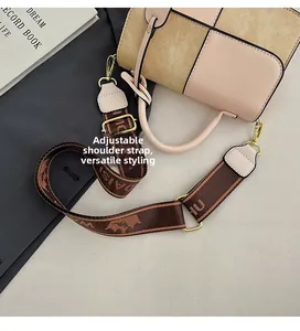 Detail of adjustable geometric patterned wide shoulder strap on color-block crossbody bag