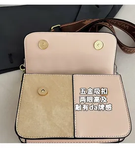 Detail of color-block flap bag with gold magnetic snaps and jacquard wide strap