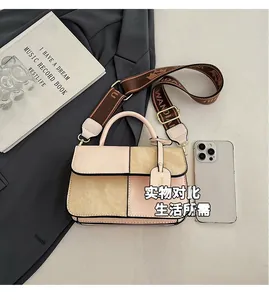 Detail view of pink and khaki color-block crossbody bag with wide printed shoulder strap