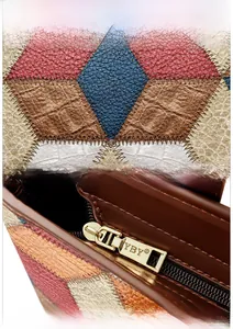 Detail of color block tote bag featuring crocodile and lychee leather textures with gold zipper
