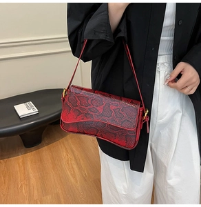 Close-up of vintage red and black snake skin texture on a stylish baguette handbag