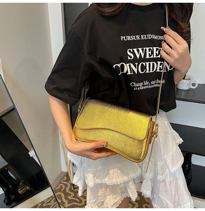 Close-up of golden faux snake skin texture on a small crossbody bag with thin strap