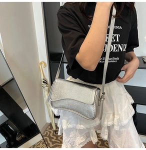 Detail of silver metallic textured crossbody bag with mesh pattern and adjustable strap