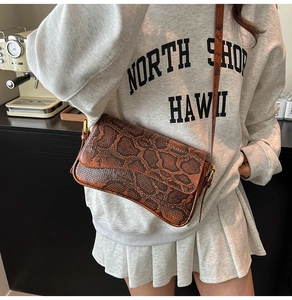 Close-up of brown snakeskin pattern texture on vintage style rectangular shoulder bag
