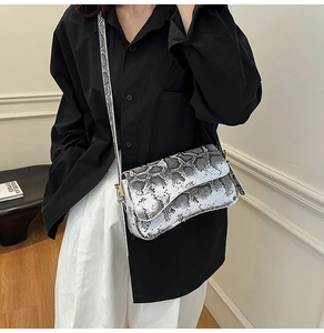 Detail of crossbody small square bag featuring black and white snake skin pattern texture