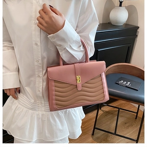 Detail of pink and khaki quilted handbag with wave pattern and gold twist lock