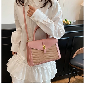Pink and beige wave textured handbag shown on a model in a stylish lifestyle setting