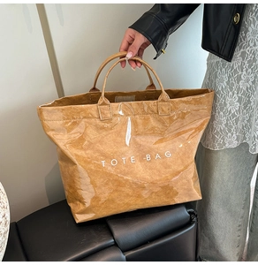 Dettaglio della borsa tote in carta DuPont marrone con rivestimento lucido e logo