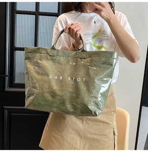 Dettaglio della borsa tote in PVC trasparente con interno verde e scritta TOTE BAG