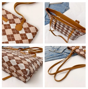 Detailed close-up of brown argyle tote bag showing leather straps and metal zipper closure