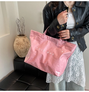 Dettaglio della borsa tote rosa in carta DuPont con strato in PVC indossata da modella