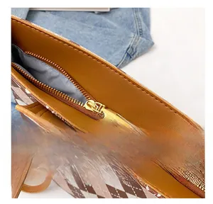 Detailed view of the smooth golden metal zipper and checkered synthetic leather texture