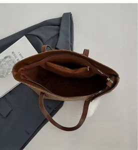 Internal view of brown tote bag showing fabric lining, zipper pockets and storage space