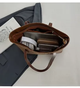 Interior view of large brown tote bag showing spacious compartments for laptop and gadgets