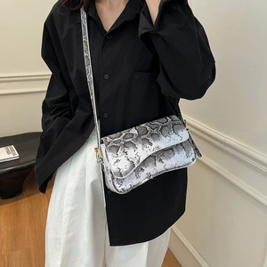 Vintage black and white snakeskin crossbody bag with gold hardware and flap closure