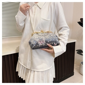 Close-up of luxury velvet shell bag with delicate pearl beads and butterfly embroidery