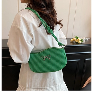 Dettaglio borsa a spalla intrecciata verde con fiocco argento e tracolla in corda spessa