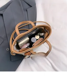 Vue intérieure montrant la grande capacité du sac en cuir marron avec des objets quotidiens