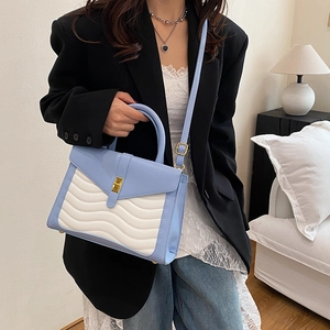 Blue and white wave-textured crossbody bag with gold buckle and adjustable strap