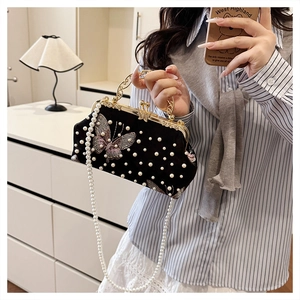 Detailed close-up of black velvet shell bag with pearl decor and butterfly embroidery