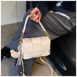 Détail du mini sac crème avec gaufrage floral et ourson, orné d'un pendentif en peluche