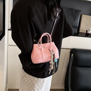 Petit sac seau en cuir grainé rose avec bandoulière et pendentif sucette ludique chic