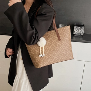 Brown leather tote bag with vintage letter patterns and white fur pompom accessory