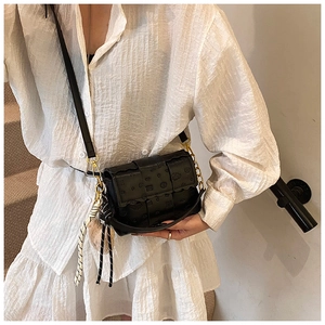 Gros plan du sac bandoulière noir embossé avec chaîne dorée et foulard en soie