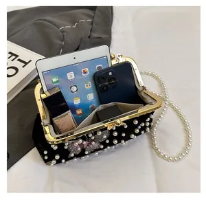 Interior view of black velvet shell bag showing spacious storage and pearl strap details