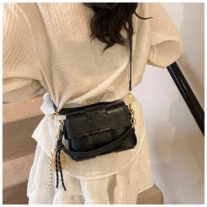 Détail du petit sac noir avec motif ours gaufré et pendentif tissé à rayures