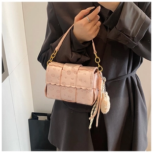 Détail d'un sac bandoulière rose avec gaufrage de dessin animé et chaîne dorée