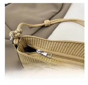 Macro detail of the smooth silver metal zipper and woven texture on a straw handbag