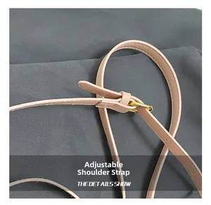 Détail de la bandoulière réglable en cuir rose avec boucle dorée et coutures de précision